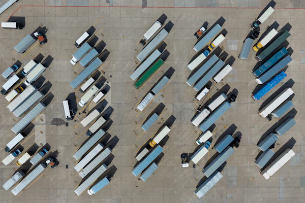 Aerial view of organized truck parking lot with multiple commercial vehicles in rows