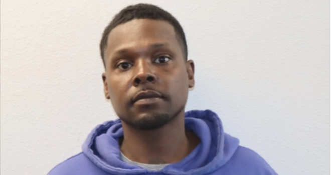 Portrait of a man wearing a blue hoodie against a white background
