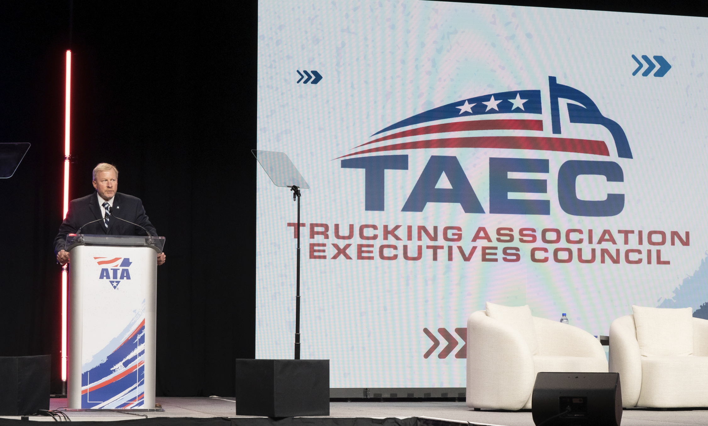 Professional speaker at podium during TAEC Trucking Association Executives Council conference presentation