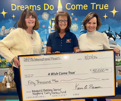 Three women holding a $50,000 check for A Wish Come True charity at a Disney-themed event backdrop dated 10/23/26