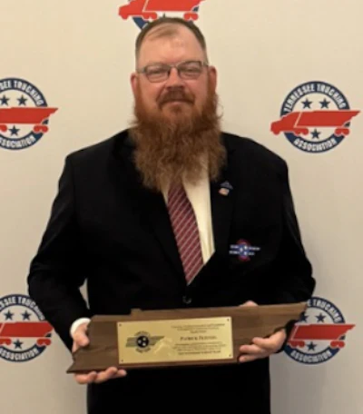 Man in suit holding award plaque at aviation industry event